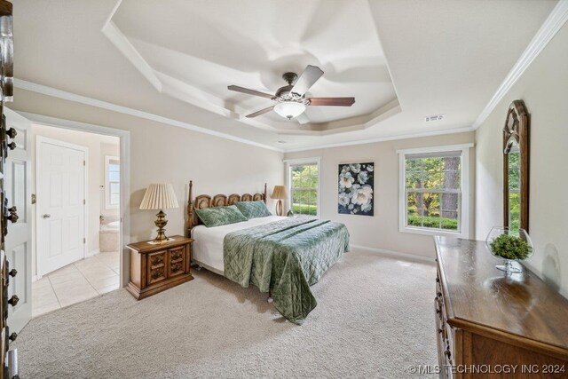 bedroom featuring ensuite bathroom, multiple windows, light colored carpet, and ceiling fan