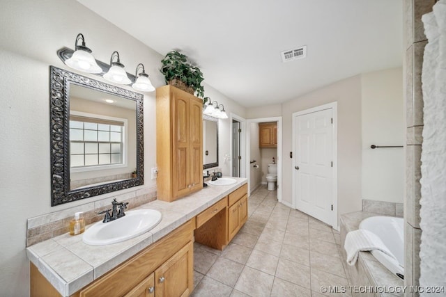 bathroom with vanity, toilet, tile patterned flooring, and a bathing tub