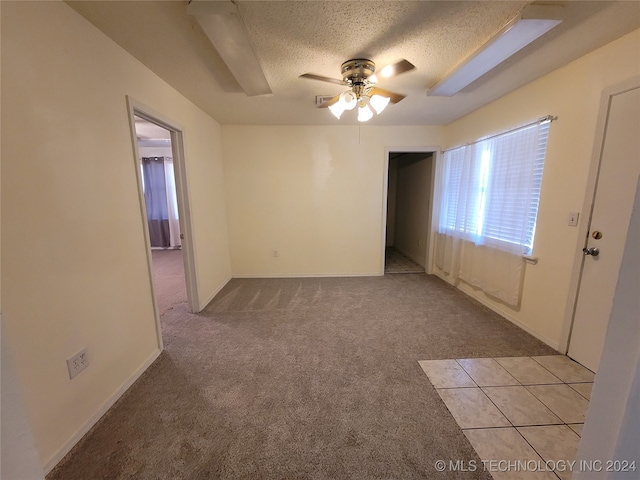 carpeted empty room with a textured ceiling and ceiling fan