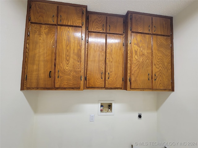 laundry area with cabinets, a textured ceiling, washer hookup, and electric dryer hookup