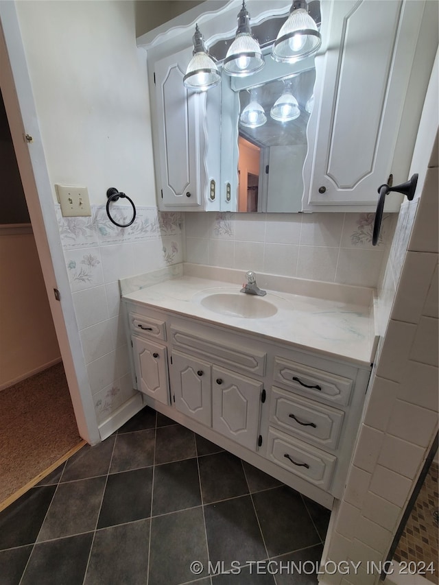 bathroom with tile walls, vanity, a chandelier, and tile patterned floors