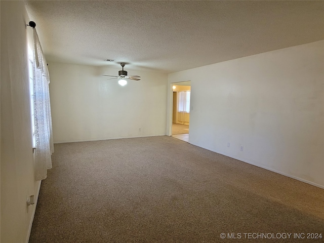 carpeted empty room with a textured ceiling and ceiling fan