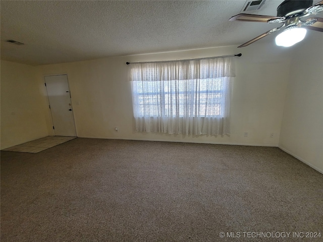 spare room with ceiling fan, carpet flooring, and a textured ceiling