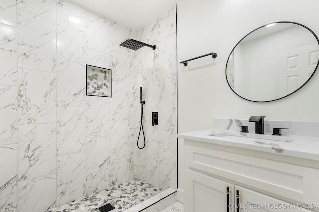 bathroom featuring a tile shower and vanity