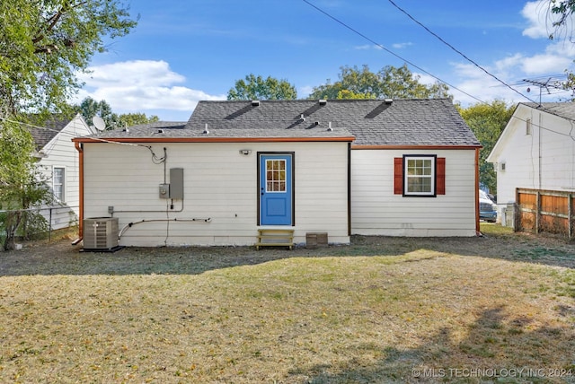 back of property featuring central AC and a lawn