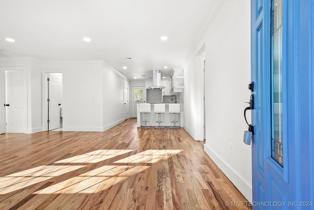 unfurnished living room with crown molding and light wood-type flooring