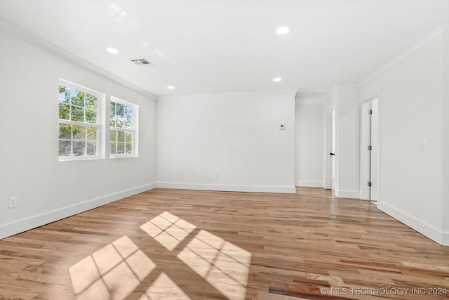 unfurnished room featuring ornamental molding and light hardwood / wood-style flooring