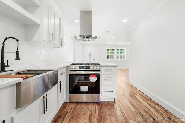 kitchen featuring gas range, white cabinetry, island range hood, and light wood-type flooring