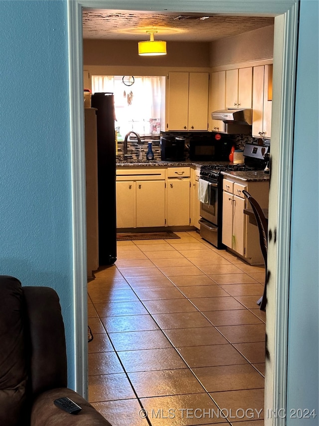 kitchen featuring sink, refrigerator, cream cabinetry, and gas stove