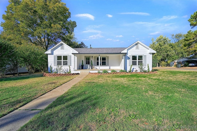 ranch-style home with covered porch and a front yard