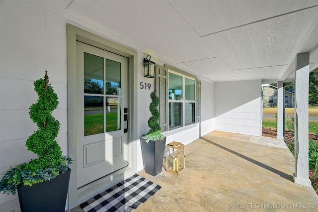 view of exterior entry with a porch