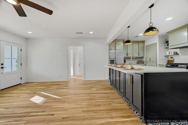 kitchen with sink, green cabinets, stainless steel fridge with ice dispenser, decorative light fixtures, and light wood-type flooring