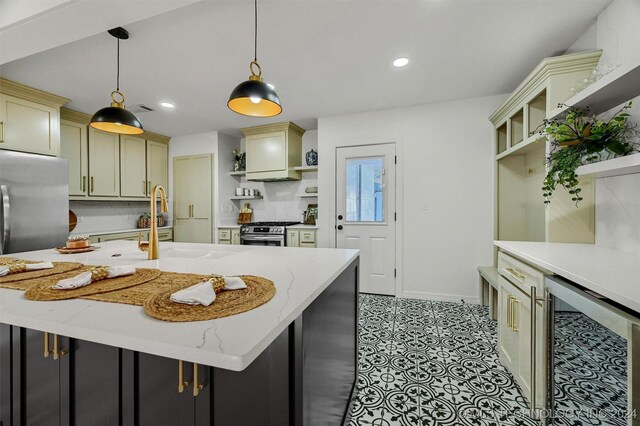 kitchen featuring pendant lighting, backsplash, wine cooler, light stone countertops, and an island with sink