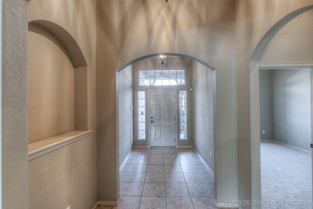 tiled foyer entrance with a towering ceiling