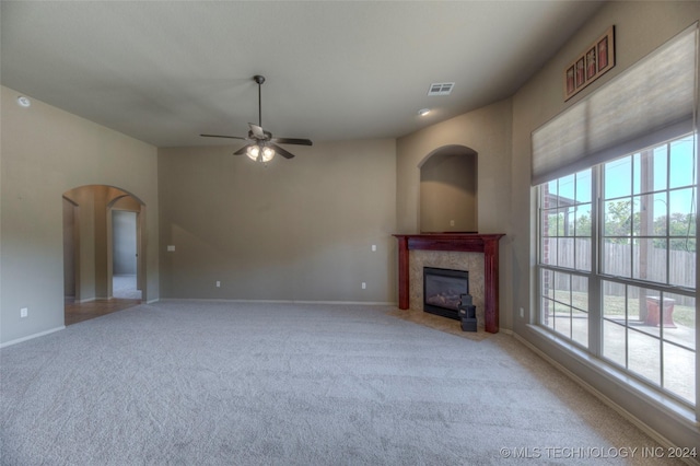 unfurnished living room with ceiling fan, a premium fireplace, and carpet