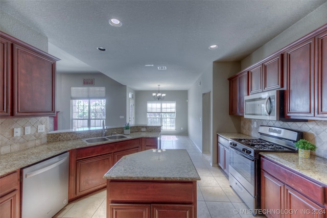 kitchen featuring appliances with stainless steel finishes, sink, pendant lighting, and light tile patterned floors