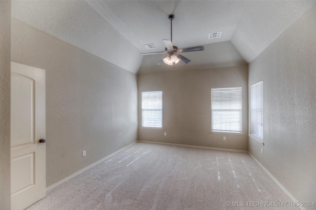 carpeted empty room featuring ceiling fan and lofted ceiling