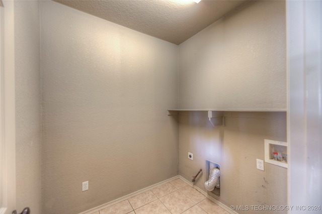 laundry area with light tile patterned floors, hookup for a washing machine, a textured ceiling, and electric dryer hookup