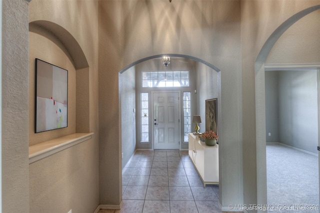 entrance foyer with a towering ceiling and light tile patterned floors