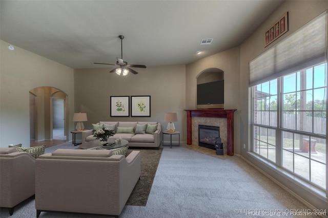 carpeted living room featuring a fireplace and ceiling fan