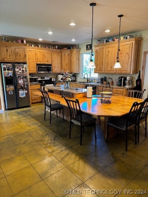 kitchen featuring appliances with stainless steel finishes, sink, and pendant lighting