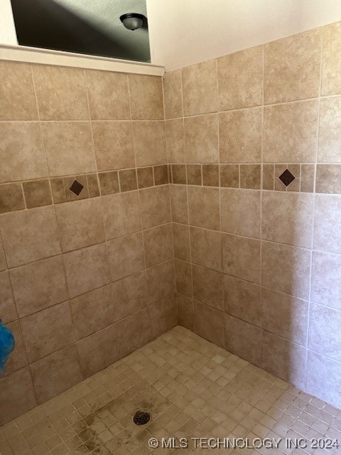 bathroom with tiled shower