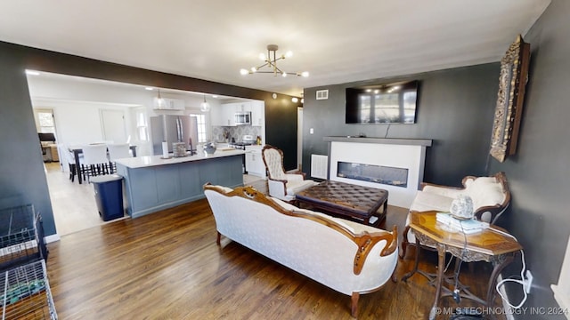 living room featuring a chandelier and wood-type flooring