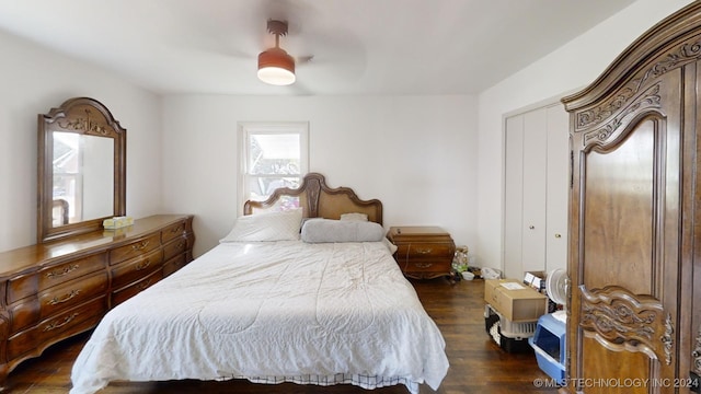 bedroom with a closet, dark wood-type flooring, and ceiling fan