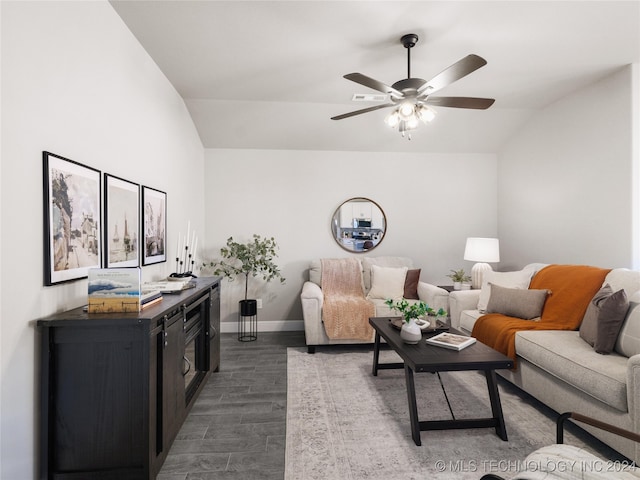 living room with dark wood-type flooring, vaulted ceiling, and ceiling fan