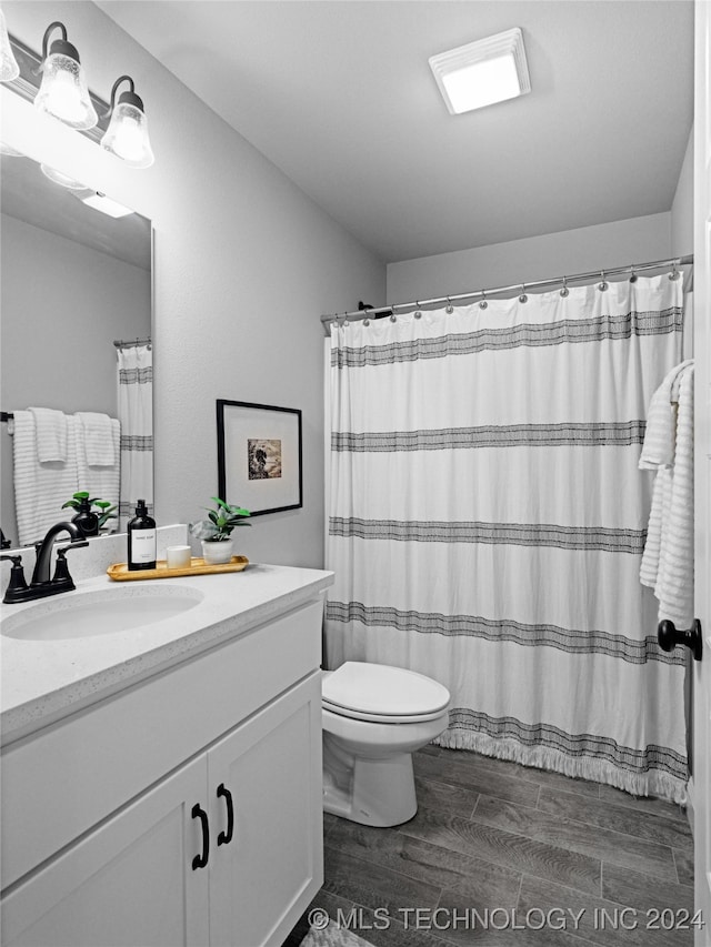 bathroom with vanity, hardwood / wood-style flooring, toilet, and a shower with shower curtain