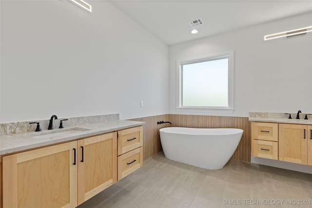 bathroom featuring wooden walls, vanity, and a bath