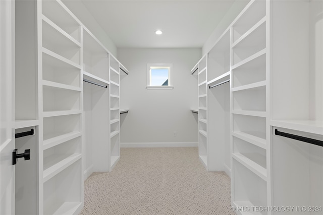 walk in closet featuring light colored carpet