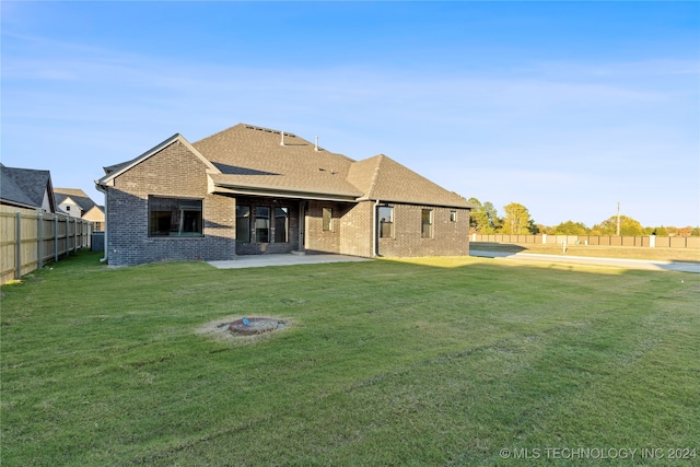 rear view of property with a patio and a lawn