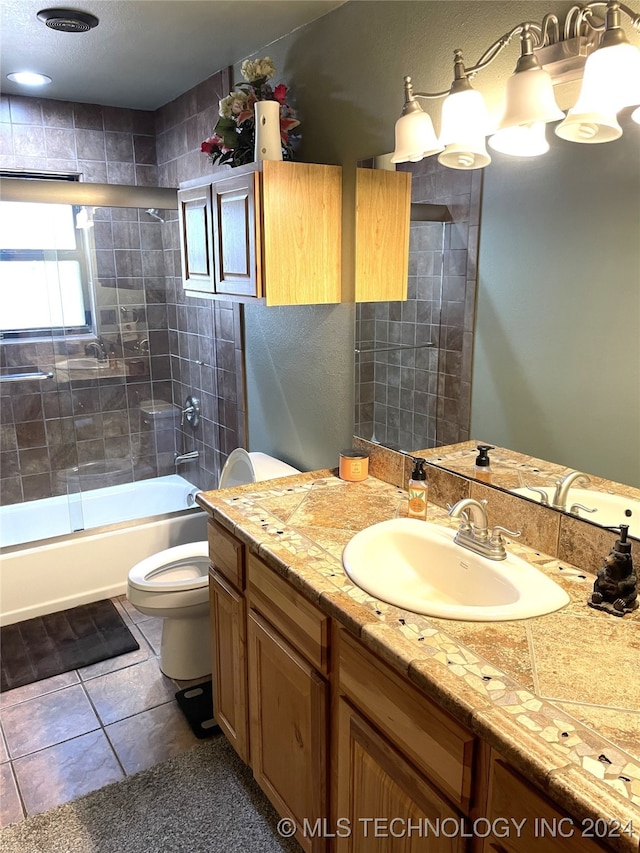 full bathroom featuring vanity, bath / shower combo with glass door, toilet, and tile patterned flooring