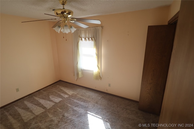 carpeted empty room with a textured ceiling and ceiling fan