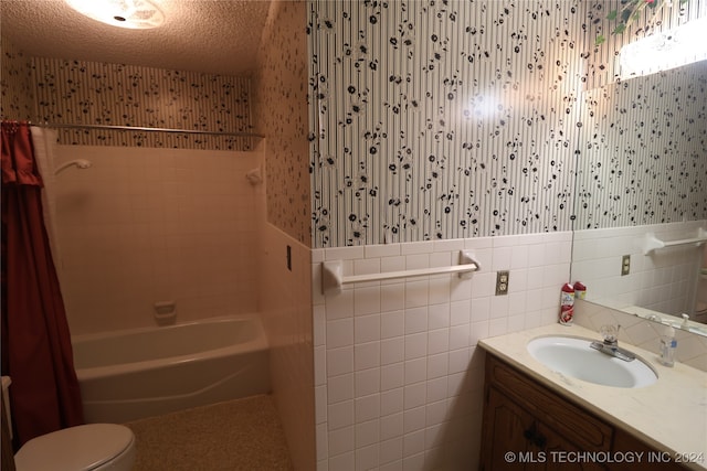 full bathroom with toilet, vanity, tile walls, a textured ceiling, and shower / bathtub combination with curtain