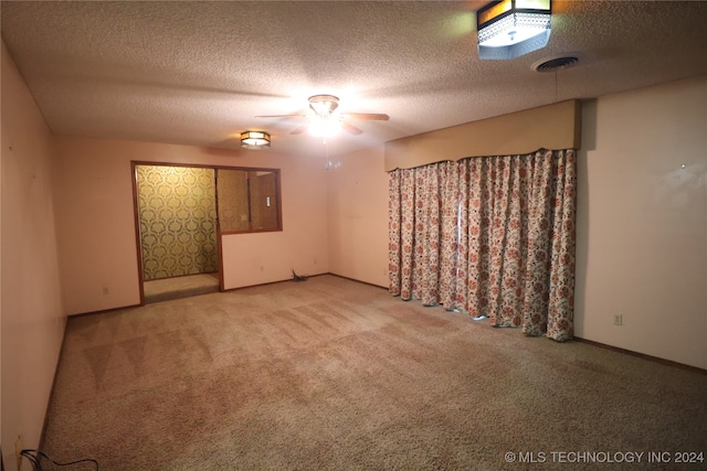 unfurnished room with ceiling fan, carpet flooring, and a textured ceiling