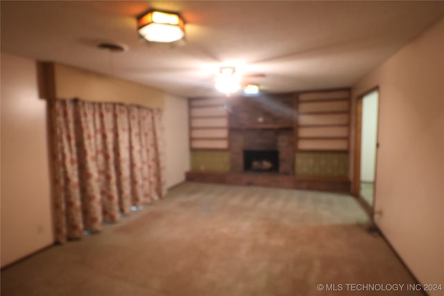 unfurnished living room with light colored carpet and a fireplace