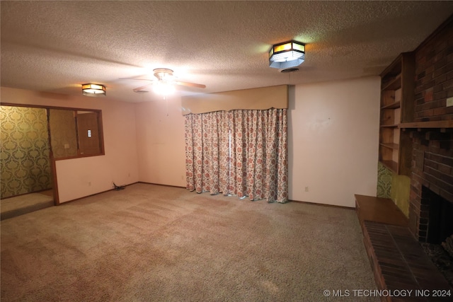 basement with a textured ceiling, carpet, and a brick fireplace