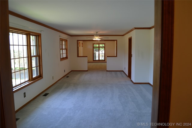 carpeted empty room featuring crown molding and ceiling fan