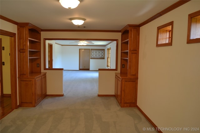 hallway featuring ornamental molding and light colored carpet