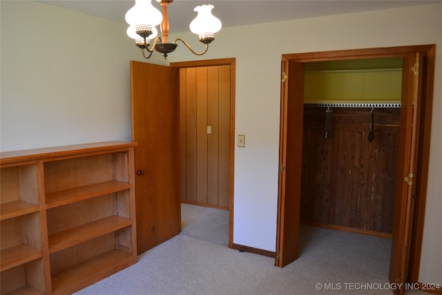 bedroom with a notable chandelier, a closet, and light colored carpet