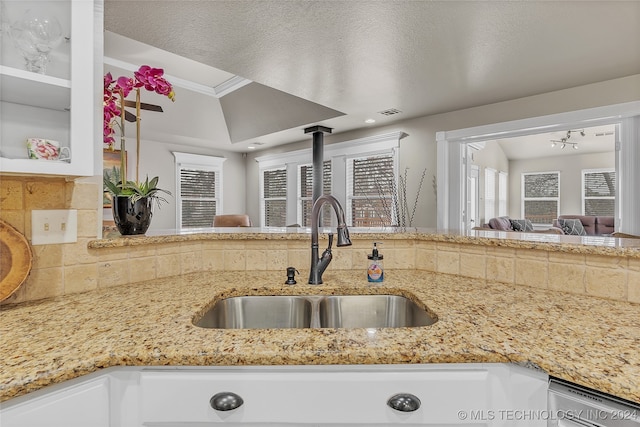 kitchen featuring tasteful backsplash, white cabinetry, a textured ceiling, crown molding, and sink