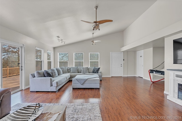 living room featuring a wealth of natural light, dark wood-type flooring, vaulted ceiling, and ceiling fan