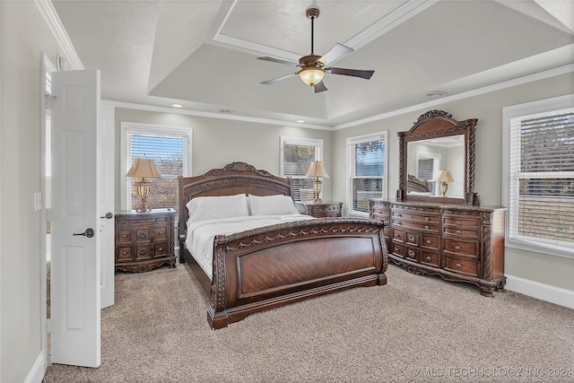 carpeted bedroom featuring ornamental molding, a tray ceiling, and ceiling fan