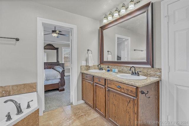 bathroom with vanity, tiled tub, and ceiling fan