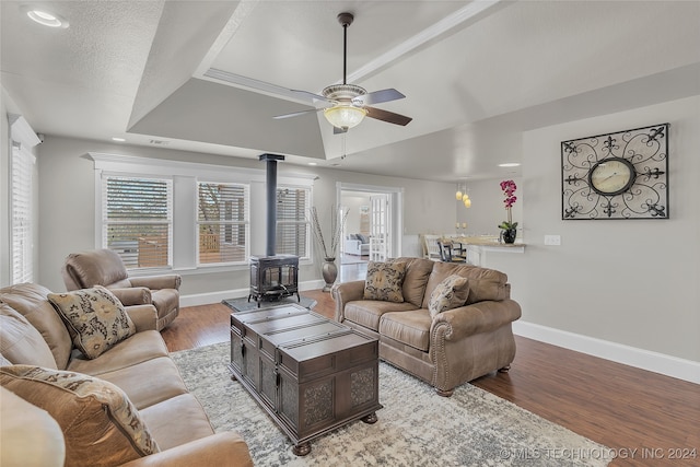 living room with ceiling fan, a wood stove, and light wood-type flooring