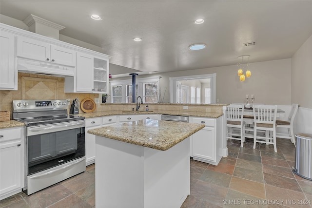 kitchen featuring appliances with stainless steel finishes, sink, backsplash, a center island, and kitchen peninsula