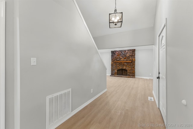 corridor with light hardwood / wood-style flooring and a chandelier