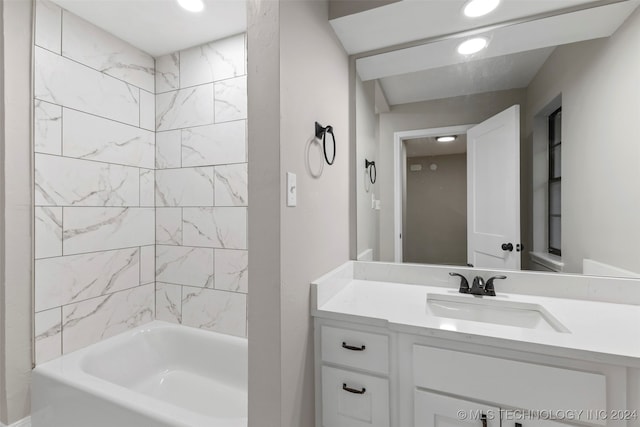 bathroom featuring tiled shower / bath and vanity